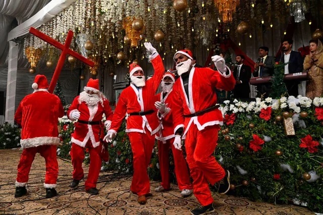 Christian devotees dressed as Santa Claus take part in a special service ahead of the Christmas in Lahore. (Photo by ARIF ALI/AFP 2020 via Getty Images)