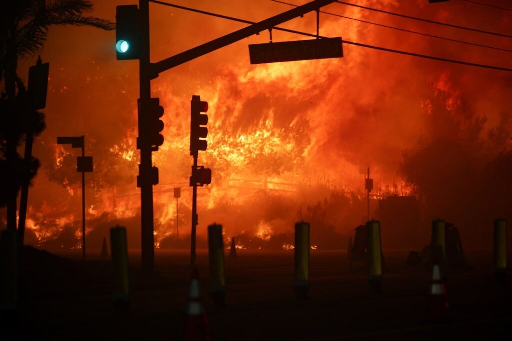 A rapidly growing wildfire raged across a section of Los Angeles, destroying homes and creating traffic jams as 30,000 people evacuated.