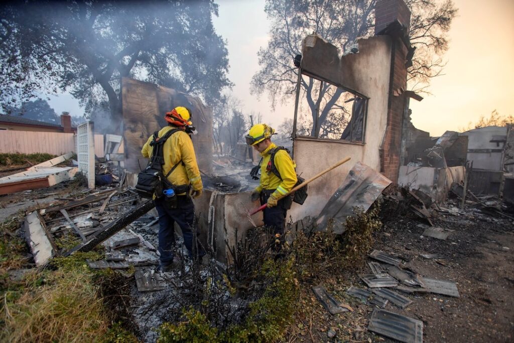 A pair of massive fire menacing Los Angeles from the east and west were still burning uncontained, two days after they ignited.