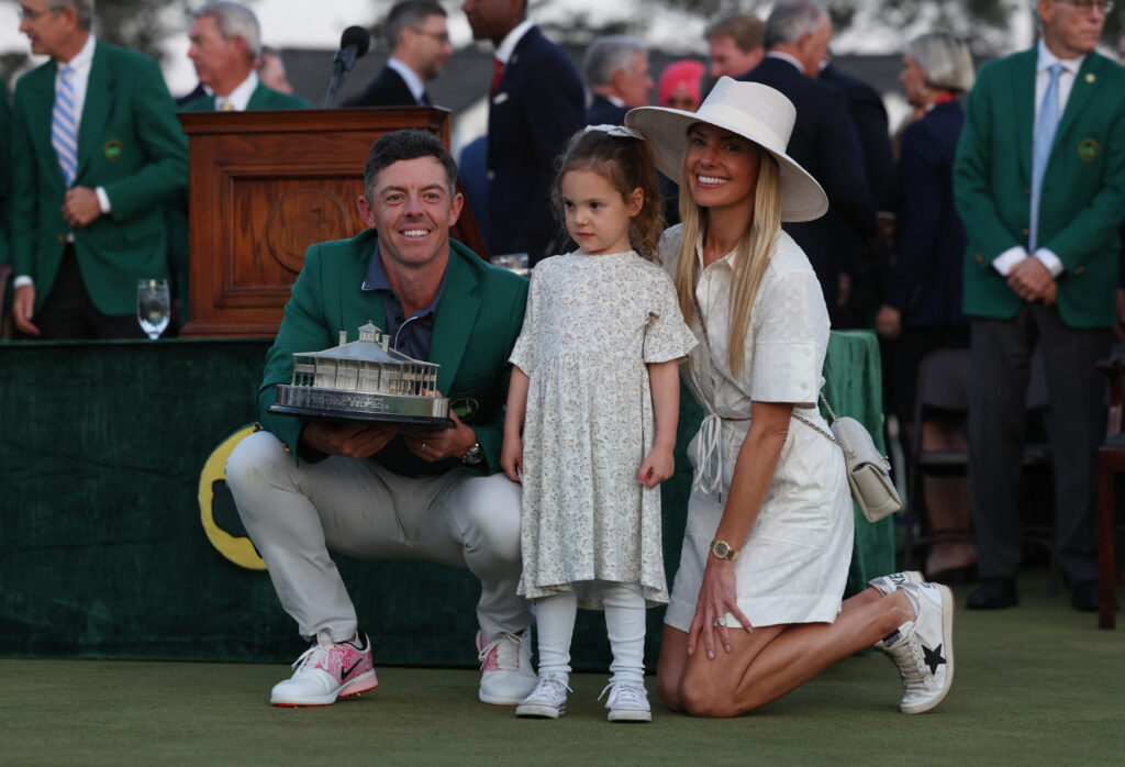 Golf - The Masters - Augusta National Golf Club, Augusta, Georgia, U.S. - April 13, 2025 Northern Ireland's Rory McIlroy celebrates wearing his green jacket and holding the trophy with his wife Erica Stoll and their daughter Poppy after winning The Masters and completing a career grand slam REUTERS/Pilar Olivares