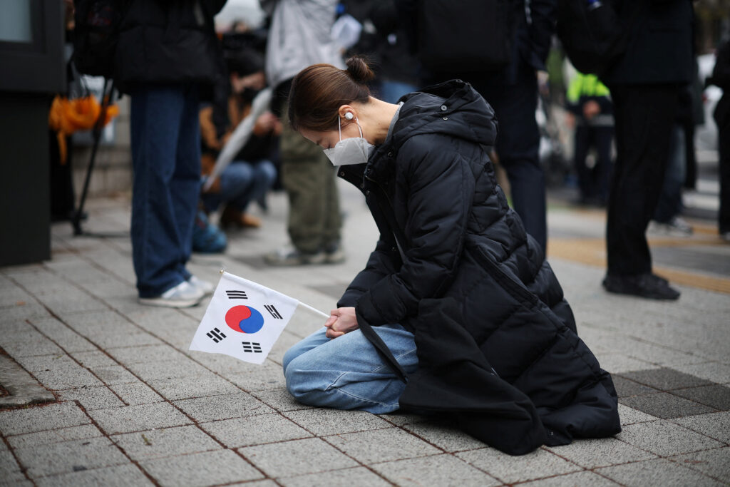 A far-right protester prays for South Korea's ousted President Yoon Suk Yeol who will attend the first arguments in the criminal case of insurrection charges against him, in front of Seoul Central District Court in Seoul, South Korea, April 14, 2025.  REUTERS/Kim Hong-Ji